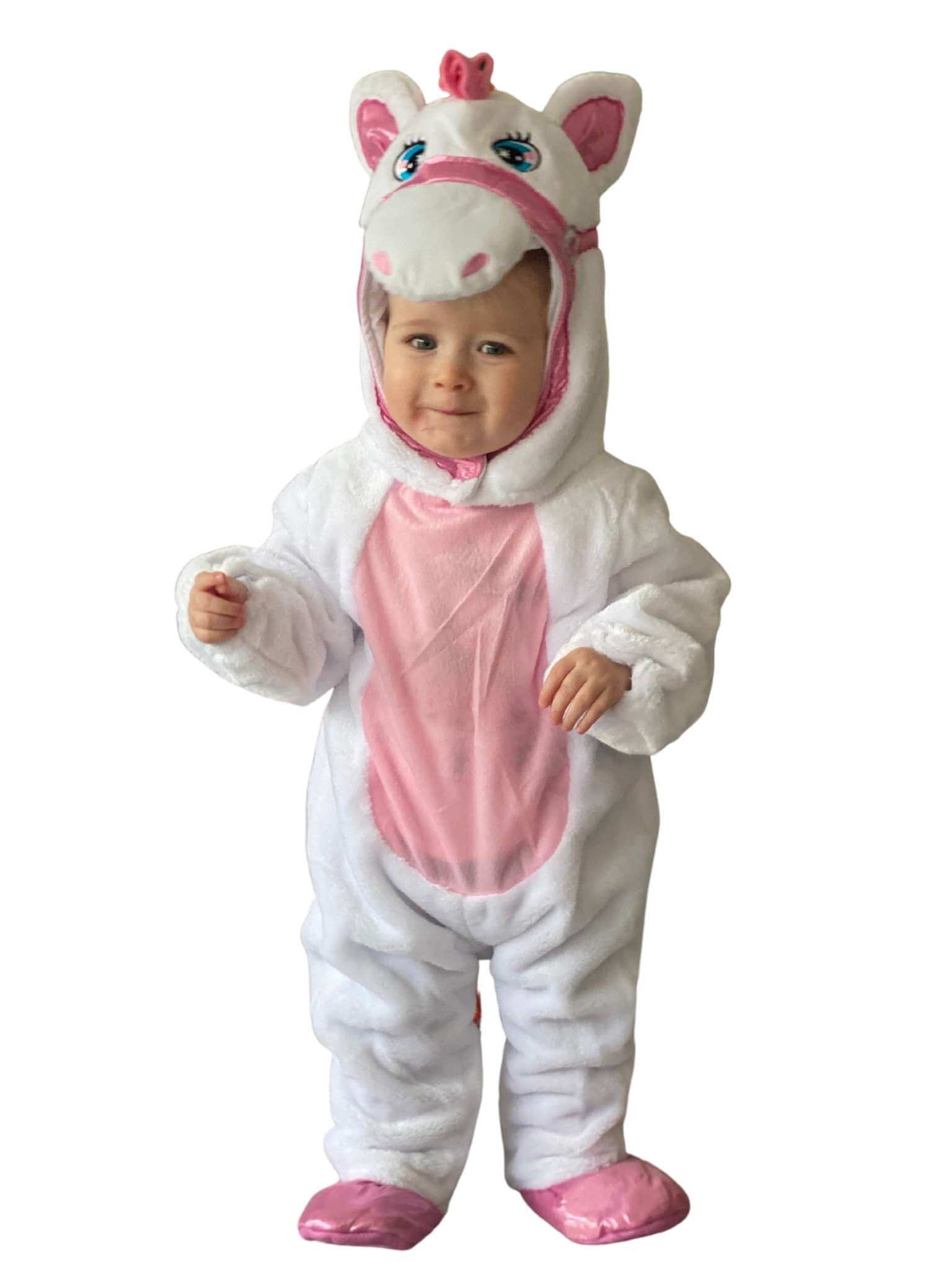 Toddler wearing a plush white unicorn onesie with pink tummy and white unicorn head with embroidered face.