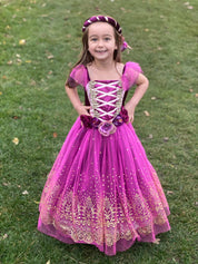 Girl stood on grass wearing the plum and gold princess dress.